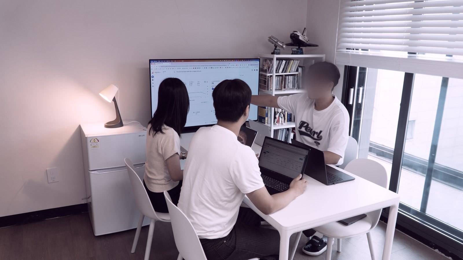 지아이코퍼레이션 팀이 한 화면을 함께 보며 지표를 확인하는 모습